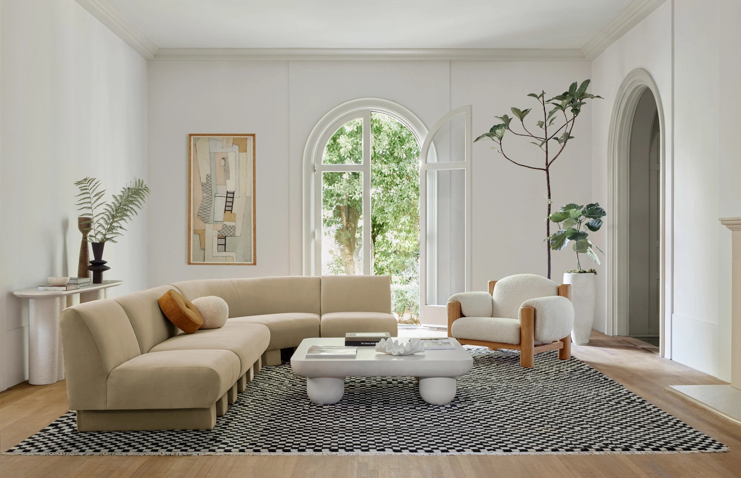 Modern living room with beige sectional sofa, coffee table, and decorative elements.