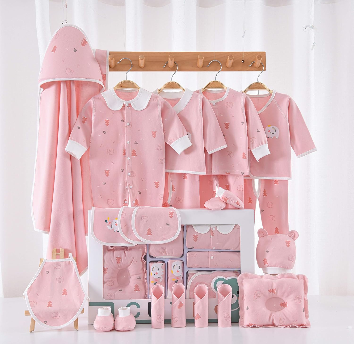 Collection of pink baby clothing and accessories on a white background